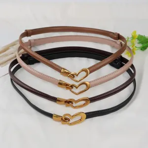 Thin leather belt for women with gold heart buckle, stylish dress accessory detail view