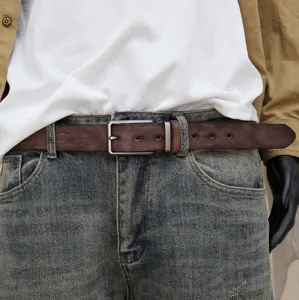 Close-up of men's brown leather belt with durable metal pin buckle and fine textured finish.