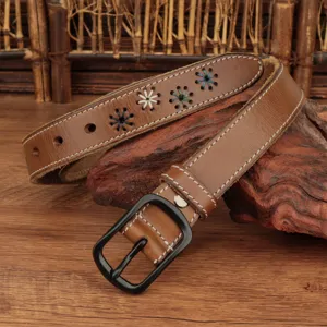 Detail view of brown leather belt with floral embroidery and black matte buckle