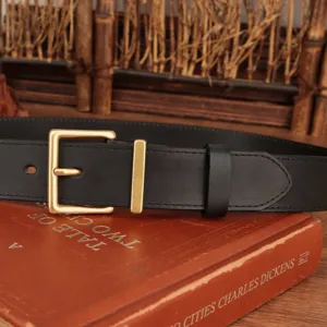 Detailed close-up of a classic black leather belt with an antique brass square buckle