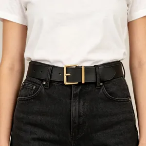 Close-up view of a classic black leather belt featuring a square gold buckle on jeans.