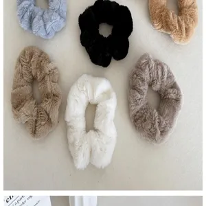 Vue détaillée de plusieurs chouchous en fausse fourrure pelucheuse aux tons thé au lait