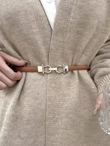 Sottile cintura in pelle marrone da donna con dettaglio di fibbia metallica primo piano