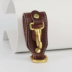 Detailed view of brown leather belt key holder with durable brass hook and neat white stitching.