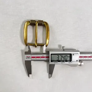 Detailed view of vintage brass belt buckle being measured with digital caliper, 37.40mm.