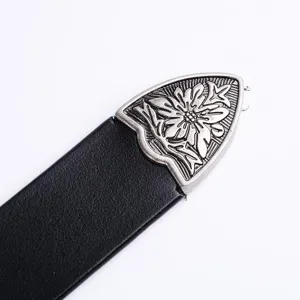Detail shot of a vintage western style black leather belt with an antique silver metal floral tip.