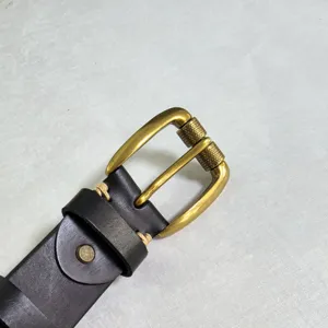 Mens vintage leather belt detail showcasing brass roller buckle and heavy stitching style