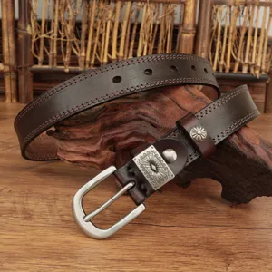 Detailed view of dark brown vintage leather belt with ornate metal buckle and stitching.