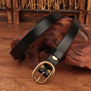 Detailed shot of a black genuine leather women's belt with vintage brass buckle and loop.