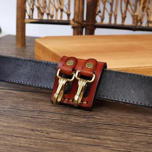 Detail view of genuine leather belt key holder with brass hooks and metal snap design.