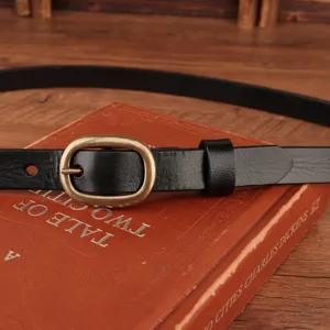 Detail view of women's black genuine leather belt with classic vintage brass metal buckle.