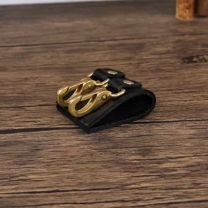 Close-up detail of the black leather belt loop key holder featuring double brass lobster clasps.
