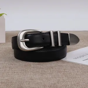 Close-up detail shot of a black leather women's belt with vintage silver horseshoe buckle.
