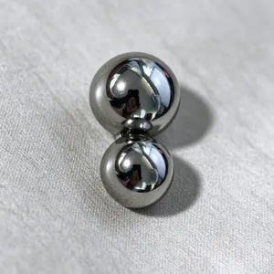 Close-up macro view of minimalist silver asymmetric double-ball metal buckle accessory