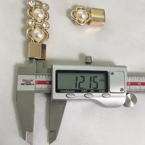 Accessorio per fibbia cintura dorato con design di fiore di perla e strass scintillanti.