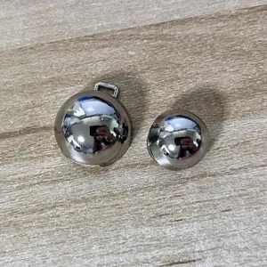 Detailed macro view of two polished silver spherical belt buckles on a wood surface