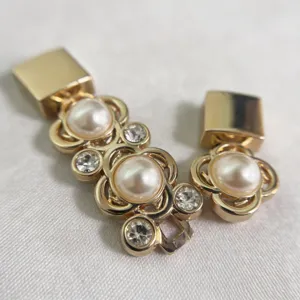 Primo piano dettagliato della fibbia per cintura in metallo dorato con perle e strass scintillanti.