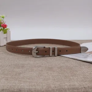 Brown leather belt for women with minimalist horseshoe buckle and stylish metal tip detail.
