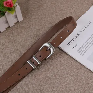 Brown leather belt detail view featuring a vintage silver horseshoe buckle and dual loops.