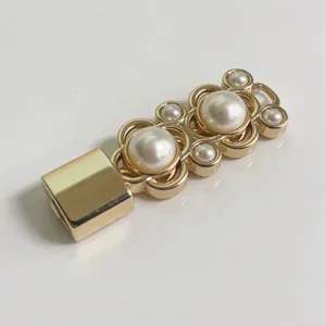 Dettaglio fibbia per cintura in metallo dorato, decoro floreale di perle, accessorio moda