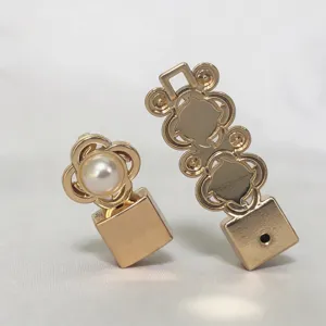 Vista dettagliata degli accessori per fibbia di cintura in metallo dorato con perla.