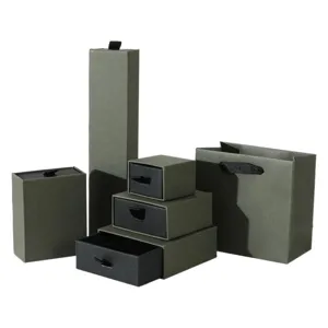 Various sizes of vintage green and black drawer jewelry boxes with matching gift bag