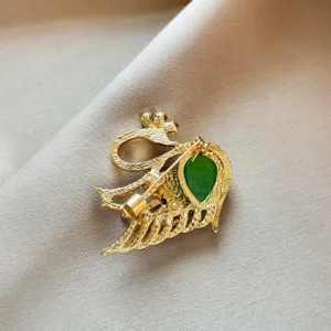 Close-up detail shot showing the secure pin backing and green stone inlay of the elegant brooch.