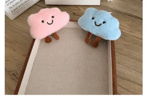 Détail de mignons pendentifs en peluche nuage rose et bleu pour sacs et vêtements