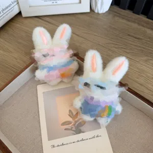 Pendentifs en peluche lapin blanc mignon sur un plateau décoratif en bois