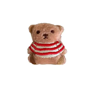 Mignon écusson d'ours en peluche marron avec un pull décoratif à rayures rouges et blanches