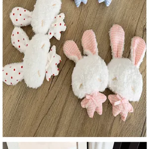 Gros plan d'adorables porte-clés lapin en peluche avec motifs à carreaux rose et pois.