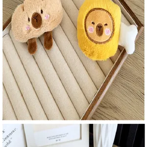 Detailopname van schattige pluchen brood- en toastbedeltjes op een fluwelen dienblad.