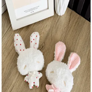 Détail de pendentifs lapins en peluche avec motifs à pois et à carreaux