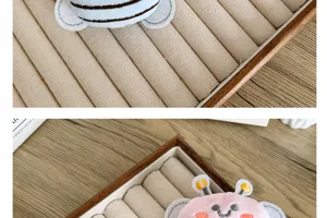 Gros plan d'adorables accessoires en peluche d'abeille sur un plateau à bijoux