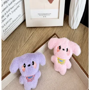 Détail de deux breloques chien en peluche avec bavoirs et joues roses.