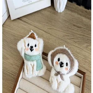 Gedetailleerd zicht op twee schattige pluche puppy-bedeltjes met zachte bonttextuur
