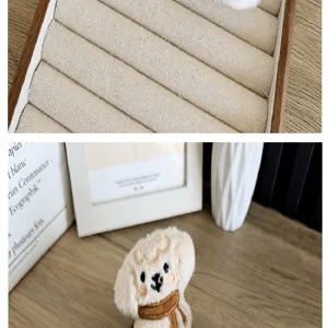 Close-up van een schattige pluche hondenbedel met een bruine sjaal op een houten bureau.