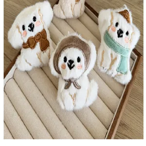 Detail van schattige witte pluche puppy broches met diverse sjaals en capuchons
