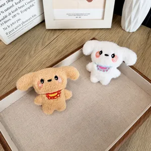 Deux adorables breloques de sac en peluche pour chiots avec bavoirs brodés sur un plateau