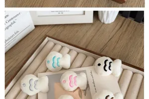 Detailed macro view of white plush fish brooches with colorful embroidered scales