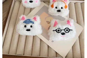 Close-up of four cartoon plush Westie dog brooches with different hat and glass accessories.