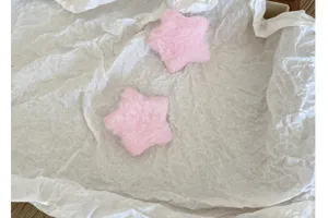 Vue détaillée de deux adorables accessoires DIY en peluche rose en forme d'étoile