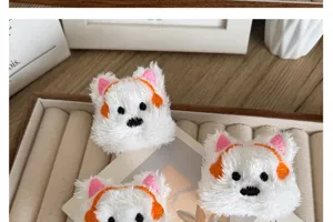 Close-up of fluffy white plush Westie puppy brooches featuring cute orange headphones