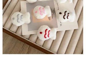 Close-up of cute plush fish brooches in various colors for DIY craft accessories