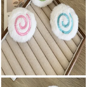 Gros plan d'accessoires de sucettes en peluche blanche avec spirales rose et bleu