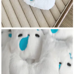 Gros plan détaillé d'une tête de chat en peluche blanche avec un motif de larme bleue.