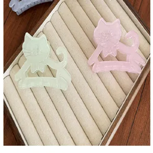 Vue rapprochée de pinces à cheveux en forme de chat en rose pastel et vert menthe