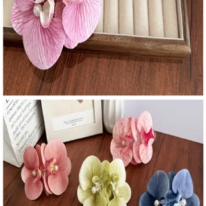 Detailed view of multi-colored large artificial orchid hair clips with pearl accents