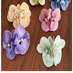 Detailed view of colorful artificial orchid hair clips with pearls on wood background