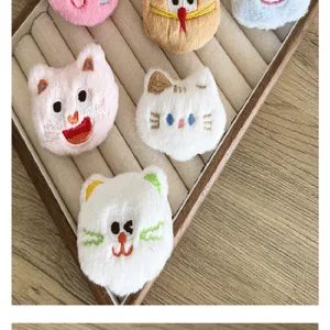 Vue rapprochée de diverses broches en peluche de chat de dessin animé sur un plateau
